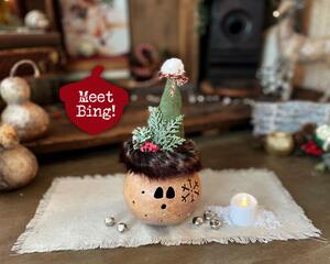 A Christmas elf collectable that has a carved face to light with a battery candle. Bing the elf has a custom pointy hat with faux fur trim.